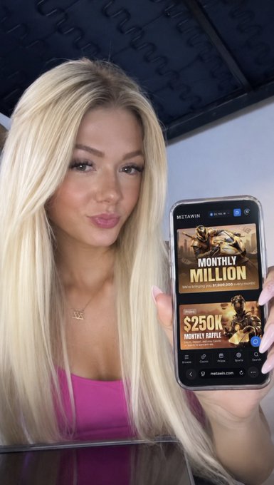 A young woman with long blonde hair holds up a smartphone displaying the MetaWin app, featuring promotions for a "Monthly Million" giveaway and "$250K Monthly Raffle," directly illustrating the post's mention of MetaWin's current deposit match offer and ongoing prize giveaways.