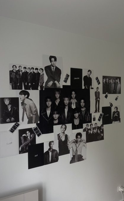 A wall decoration consisting of multiple black-and-white poster photos of a male group arranged in an overlapping collage.