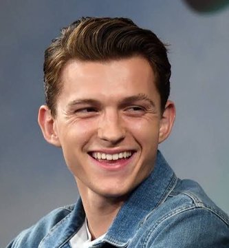 A headshot portrait of a smiling young man with short brown hair, wearing a denim jacket.