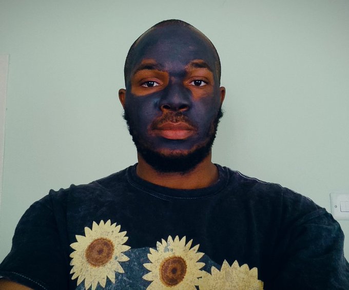 The image shows a man with a black face mask and a sunflower-patterned shirt, likely used as a profile photo for a social media post addressing rumors about his involvement with the $GAYU project and clarifying his continued support for the @Gayu_BTC community. The casual selfie serves as a personal touch to dispel misinformation and reassure followers that his silence is not a sign of conflict or disengagement with the project.