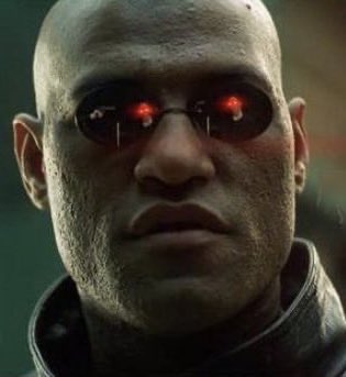 A close-up portrait of a bald, scarred man wearing dark sunglasses that reflect glowing red lights, resembling a cybernetic character from a sci-fi film.