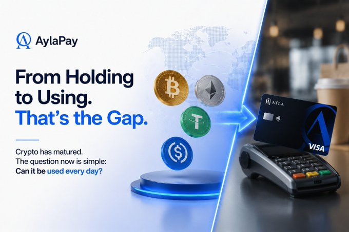 An AylaPay advertisement showing cryptocurrency coins (Bitcoin, Ethereum, Tether, USDC) with an arrow pointing to a Visa card on a payment terminal, with text 'From Holding to Using. That's the Gap.'