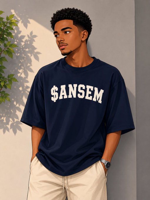 A young man wearing a navy blue t-shirt with '$ANSEM' printed in white stands against a wall beside a leafy plant.