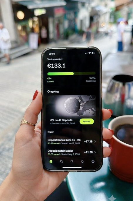 A hand with red nail polish and a gold ring holds a smartphone displaying the OKX app, which shows a total rewards balance of €133.1, including €74 earned and €59.1 upcoming, with an active "8% on All Deposits" offer valid until July 31, 2026. The image complements the post by visually showcasing the app's rewards interface, reinforcing the message about OKX's deposit incentive for EEA users.