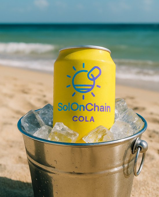 A yellow can of 'SolOnChain COLA' soda sits in a metal bucket filled with ice on a sandy beach with the ocean in the background.