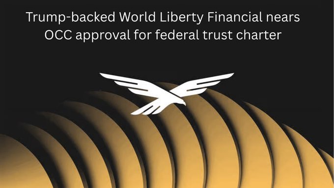 The image features a poster with various text, including "Trump-backed World Liberty Financial nears OCC approval for federal trust charters". The poster has a bird design on it, which looks like an eagle flying over some stacked circles representing different financial markets. It appears to be related to the Trump Presidential campaign or related news regarding economy and finance.