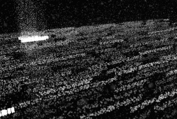 A grainy, high-contrast black-and-white image resembling a textured surface with horizontal striations and a bright rectangular highlight.