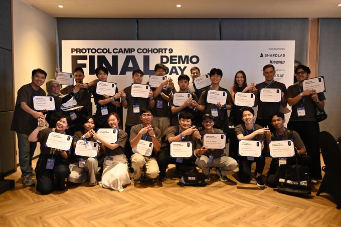 A group photo from 'PROTOCOL CAMP COHORT 9 FINAL DEMO DAY', organized by SHARDLAB, INKSED, and KRAF, showing participants holding certificates and posing together.