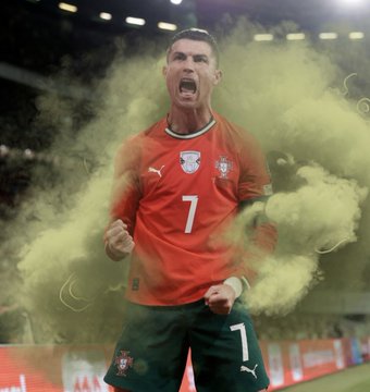 The image features a soccer player wearing an orange jersey with the number 7 on it, celebrating his victory over another team. The player is surrounded by smoke, which adds to the celebratory atmosphere of the scene. In the background, there are logos for PUB and FARTPRINT, indicating that this moment was captured in a sponsored event or advertisement.