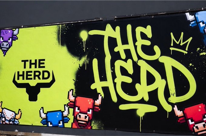 A graffiti-style mural reading "THE HERD" in large neon-green spray paint alongside pixel-art characters resembling Bullvinos from CryptoPunks, with a "THE HERD" bull logo on the left.