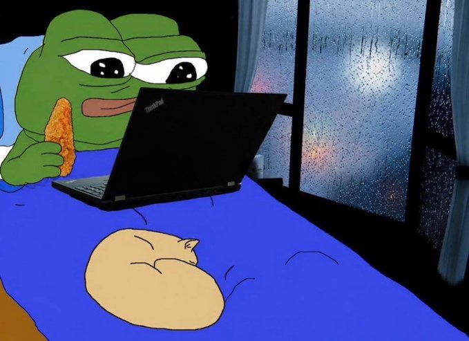 A Pepe the Frog meme holds a breaded chicken tender while staring intently at a ThinkPad laptop in bed, with another larger chicken tender resting on the blue blanket, perfectly capturing the lazy, indulgent vibe of the "$TENDIES" crypto meme that blends comfort food nostalgia with internet culture.