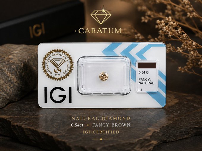 The image features an advertisement for a natural diamond, specifically a fancy brown one, with a certificate of authenticity. The diamond is displayed next to a box that says "Caratum" on it. The background shows a rock formation or a stone wall, which adds to the overall aesthetic appeal of the scene. The text in the image reads: "Fresh inventory for CARATUM. Natural Diamond  0.54 ct