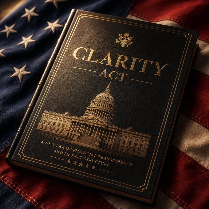 A black hardcover book titled "CLARITY ACT" with gold lettering and an embossed U.S. Capitol building rests on an American flag, symbolizing the pending financial legislation discussed in the post about Congress potentially advancing the Clarity Act and its implications for XRP holders.