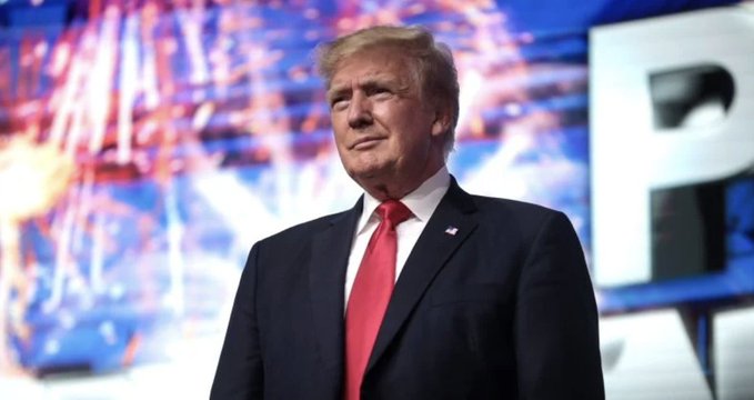 Donald Trump stands in a dark suit with a red tie against a backdrop featuring fireworks, visually accompanying a survey reporting that 63% of Americans find it inappropriate for him and his family to profit from crypto while in office.