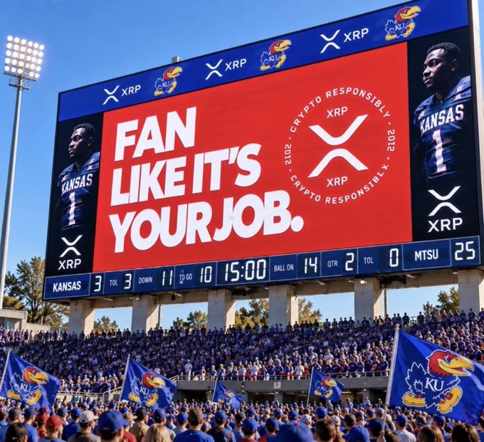 A stadium scoreboard at a Kansas vs MTSU football game displaying a red XRP advertisement reading 'FAN LIKE IT'S YOUR JOB.' with crypto responsibly warnings.