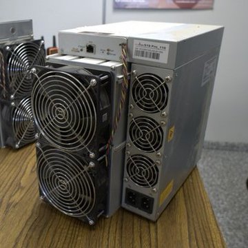 A "Red Team" initiative by the 256 Foundation examines a Bitcoin ASIC mining device featuring dual cooling fans and an ethernet port, with a partially visible "Antminer" label, to audit its firmware security and mitigate hardware-level risks.