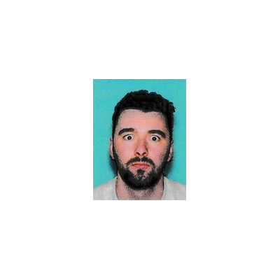 A close-up photo of a bearded man with wide eyes and a surprised expression against a teal background.