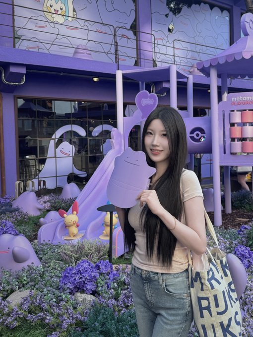A young woman poses holding a purple Pokémon cutout in front of a Pokémon-themed storefront, with a tote bag reading "MARK" and "RU" visible. The image complements the post's announcement of traveling from Shanghai (PVG) to Seoul (ICN) for Korea Blockchain Week, capturing a fun travel moment before the conference.