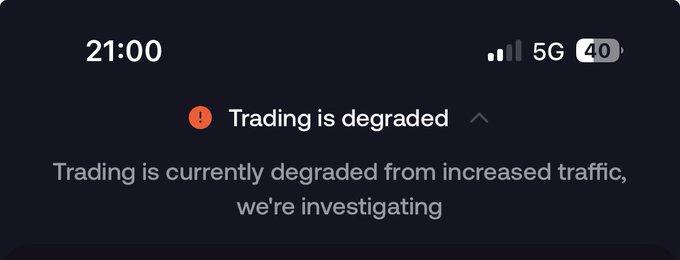 A mobile notification at 21:00 showing "Trading is degraded" with a message stating "Trading is currently degraded from increased traffic, we're investigating." The "increased traffic" warning humorously aligns with the caption "feels like a bull market," suggesting heavy market activity is overwhelming the trading platform.