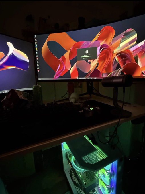 The image depicts an arrangement of computer components with a desktop computer setup including two monitors, a keyboard, a mouse, and a printer. The screens show different graphics and designs, creating a visually appealing scene. The primary focus of the photo is on the two monitors placed side by side on a desk in front of a speaker. 

The content of the post seems unrelated to the image itself. It contains information about selling computer components such as monitors for Bitcoin, a bag being sold, and possibly related content like investing or graphics design. The post does not have any direct relation to the desktop computer setup shown in the image.