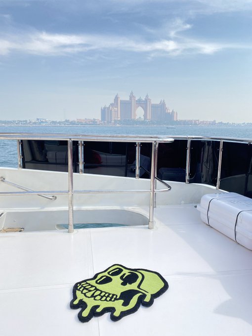 A view from a boat deck featuring a green skull rug, with the Atlantis The Palm hotel visible across the water in the distance.