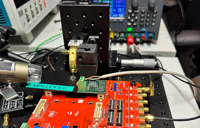 A probe station setup labeled "WALLET CC" is shown testing a Tangem hardware wallet's circuit board, with a Dino-Lit microscope and oscilloscope in the background capturing electrical signals from the card's exposed components to demonstrate a hardware vulnerability requiring specialized lab equipment and physical access to exploit.