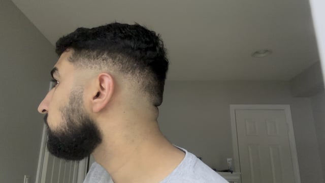 A young man shows off his fresh low taper fade haircut with a well-groomed beard, his profile view highlighting the clean blend along the side. The image relates to the post as a play on words—"similar to r/Hedera" referencing both the Hedera subreddit community and the "hedge" cut style.