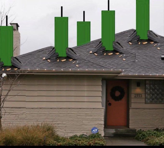 A single-story house with brown siding, a wreath on the door, and an ADT security sign, has bright green rectangular graphics digitally added above its roofline.