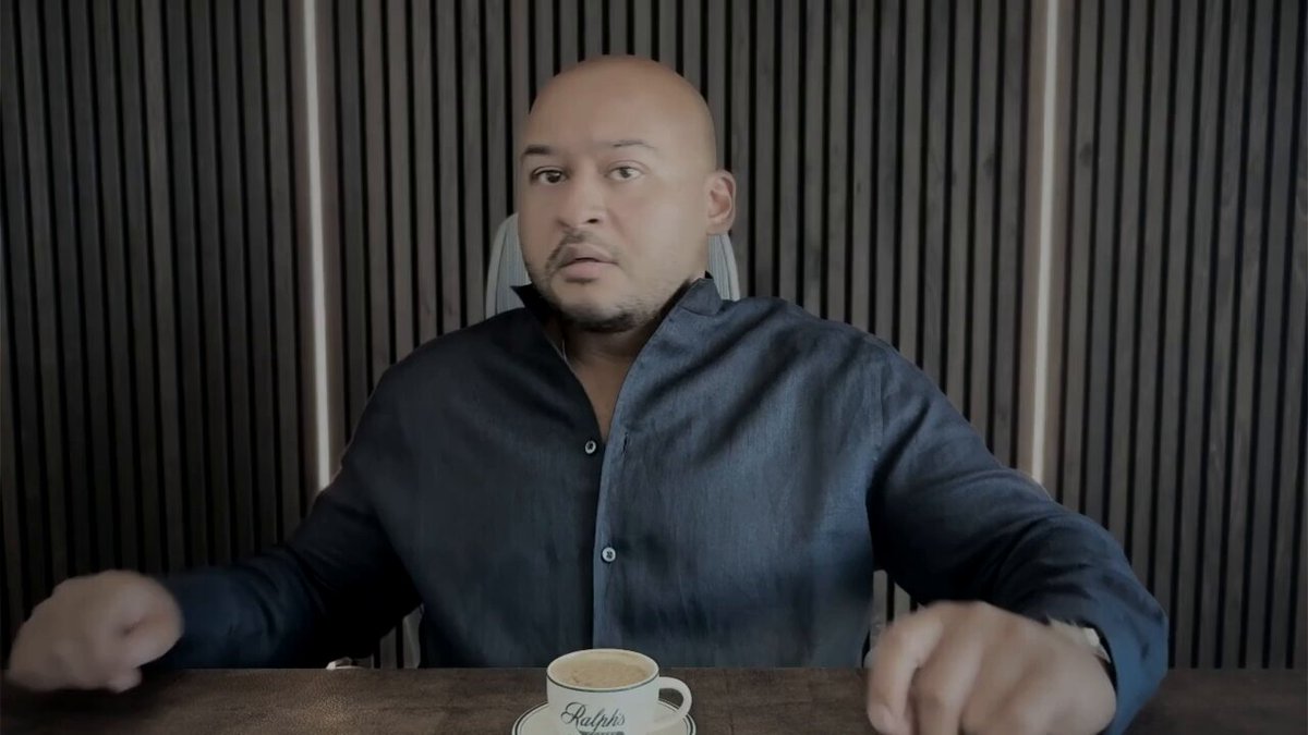 The image shows a man sitting at a table with his arms crossed, wearing a black shirt. There is a cup of coffee placed next to him on the table. The caption reads "BITCOIN SIGNAL FINALLY FLASHED!?!?!?!?!?!?!?!?!?!?!?!?!?!?!?!?!?!?!?!?!?!?!?!?!?!?!?!?!?!?!?!