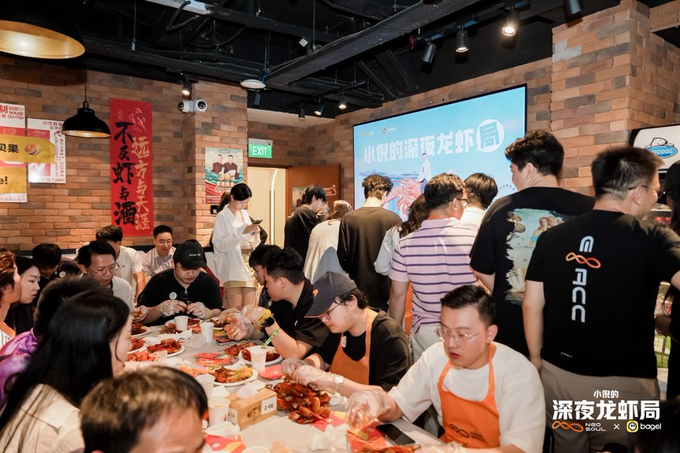 A crowded restaurant scene at 小龙の深夜龙虾局 (Xiaolong's Late Night Crayfish Bureau) with people gathered around tables eating crayfish, with OPPEIN branding visible.
