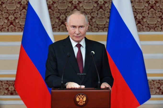 Russian President Vladimir Putin speaks at a podium, with Russian flags flanking him, as the country's central bank drafts rules for the crypto market, potentially affecting retail investors.