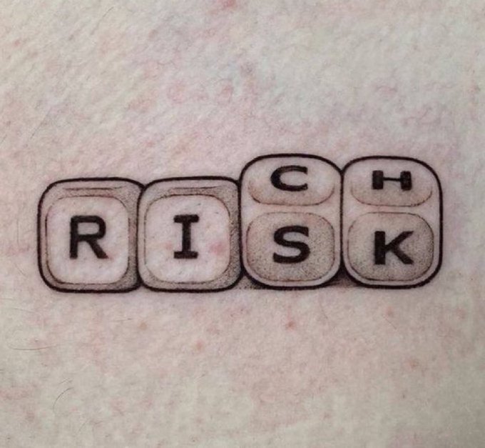 A small black-ink tattoo of four keyboard keycaps spelling out 'R I C H' on pale skin.