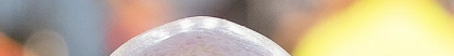 A close-up shot of what appears to be a coin or token being held up in the foreground, with blurred figures in the background, likely meant to tease the crypto community about an upcoming "runner" (a trending meme coin or token).