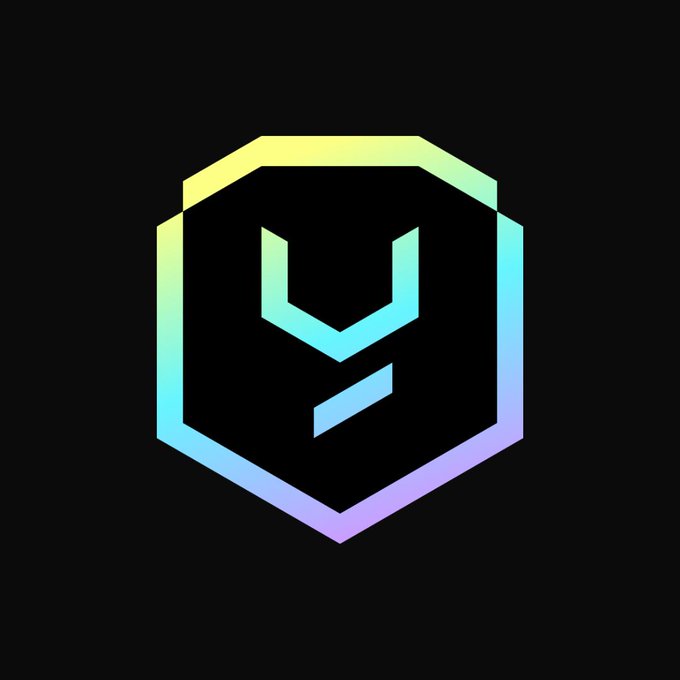 A hexagonal logo with a pastel gradient outline (yellow to purple) and a stylized "Y" emblem on a black background, representing Yield Guild Games (YGG). The image relates to the post announcing YGG's shutdown of its YGG Play sub-DAO and staff layoffs amid crypto and gaming market downturns.