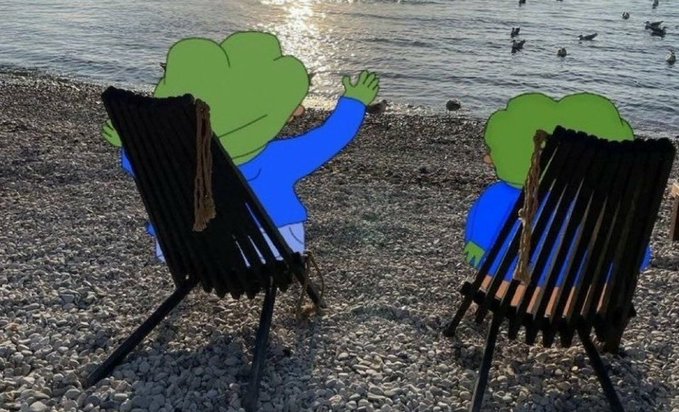 Two cartoon-style green figures with curly hair sit on wooden beach chairs by the water, with one waving toward ducks floating in the sunlit lake.
