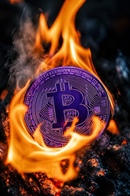 A physical Bitcoin coin with 'BITCOIN DIGITAL DECENTRALIZED PEER TO PEER' visible on it, engulfed in flames.