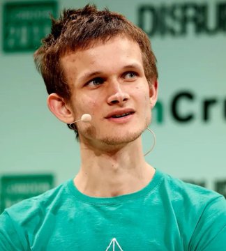 A young man with short brown hair wearing a teal t-shirt and a headset microphone, appearing to speak at a conference with a 'Disrupt' banner in the background.