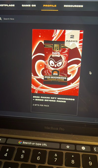 A photograph of a MacBook Pro screen displaying a marketplace profile page for '2026 PANINI NFT MOONBIRDS - BIRBS BEYOND PACKS', showing 2 NFTs per pack.
