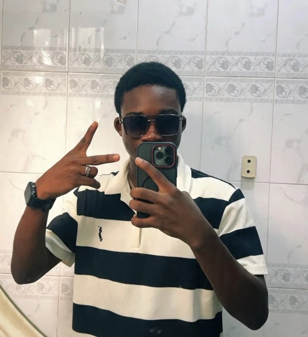 A stylish young man in sunglasses and a striped polo shirt poses with a peace sign while taking a mirror selfie in a tiled bathroom, projecting confidence as he greets his crypto community ("gm") and announces his openness to collaborations.