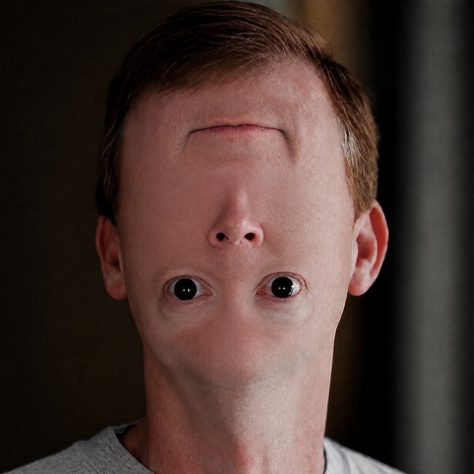 A close-up portrait shows a man whose face appears digitally altered, with his eyes positioned in the middle of his face and his nose and mouth located on his forehead.