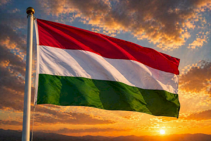 A Hungarian flag waves against a sunset sky, symbolizing the country's recent regulatory shift in the crypto sector as CoinCash secures Hungary's first MiCA license.