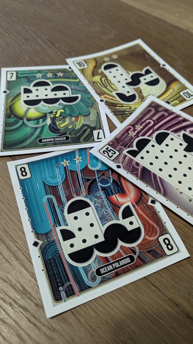 A collection of playing cards from a card game featuring various characters, including 'Harpun Chaser' (7), 'Ocean Polaroid' (8), and others, arranged on a wooden surface.