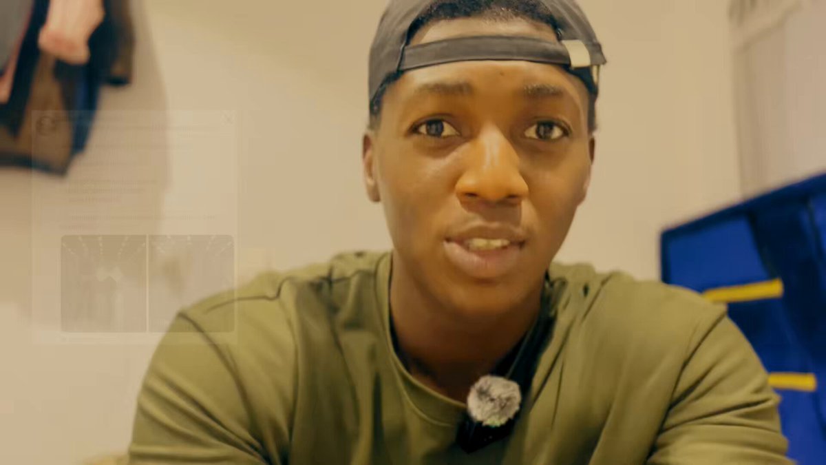 The image features a young man wearing a green shirt with a black baseball cap sitting at a desk or table. The background of the photo shows a white wall behind him, which appears to be part of an advertisement for a website called @HyperliquidX. This website is known for its 3D animation and has been featured in several posts on social media platforms like Instagram. The image also includes text that reads "DAY 521:  3D animation for @Elizacreatez Being the most famous content creator, designer, and animator in the Web3 space."