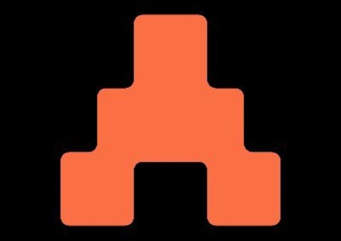 The image features an orange square logo that resembles a pyramid shape made up of three triangles stacked vertically with no base. The color of the triangle is bright orange while the other two are red, creating an eye-catching contrast against the black background. In the accompanying text, there is information about the concept of @TheARCTERMINAL and how it's changing the way users interact with Web3 by replacing traditional methods like wallets, research tools, and execution platforms with a unified operating layer for streamlined transactions.