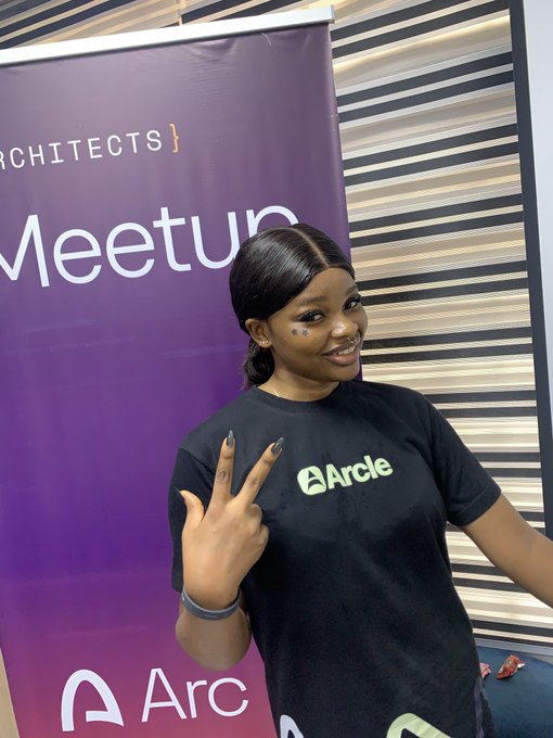 A young woman wearing a black "Arcle" t-shirt makes a peace sign while standing in front of a purple banner that reads "ARCHITECTS Meetup" and "Arc," with her caption announcing her presence at the Arc Architects Meetup and hyping up "Arcle" as a standout project on the Arc platform.