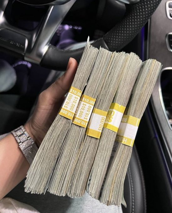 A hand displays four banded stacks of cash totaling $40,000 inside a car, visually representing the promised "unexpected money" the post claims is coming "tomorrow."
