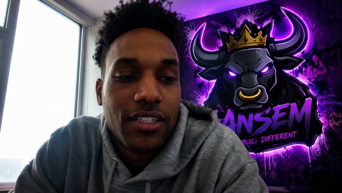 A young man in a gray hoodie speaks in front of a purple neon 'BANSEM' logo featuring a crowned bull mascot with the slogan 'BUILD DIFFERENT.'