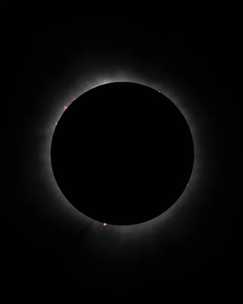 The image shows a black circle with red dots, which appears to be a solar eclipse. The sun's corona is visible through the center of the circle, creating an interesting visual effect. The caption below the image provides information about the source of the image and its relevance to the post.
