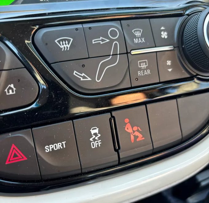 Close-up of a car's center console featuring climate controls (defrost, MAX, REAR), seat ventilation buttons with a driver figure, hazard light, SPORT mode, traction control OFF, and a child safety lock button.