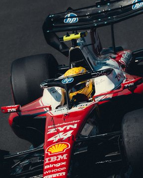 A Formula 1 Ferrari race car, adorned with sponsor logos including "hp," "Shell," "IBM," "BingX," and "Richard Mille," races under bright sunlight with its driver visible in the cockpit. The post's #SpanishGP hashtag and "lights out in just a few hours" caption align with the high-speed action of the Spanish Grand Prix, capturing the team's competitive spirit as they prepare for the race start.